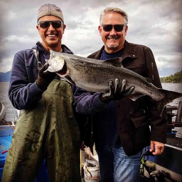 Guests holding a Silver Salmon on the dock at Salmon Falls Resort